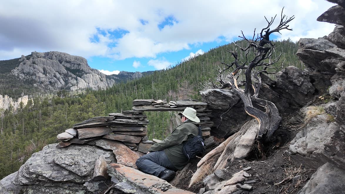 Robert Trupe resting by a stone arch in the mountains